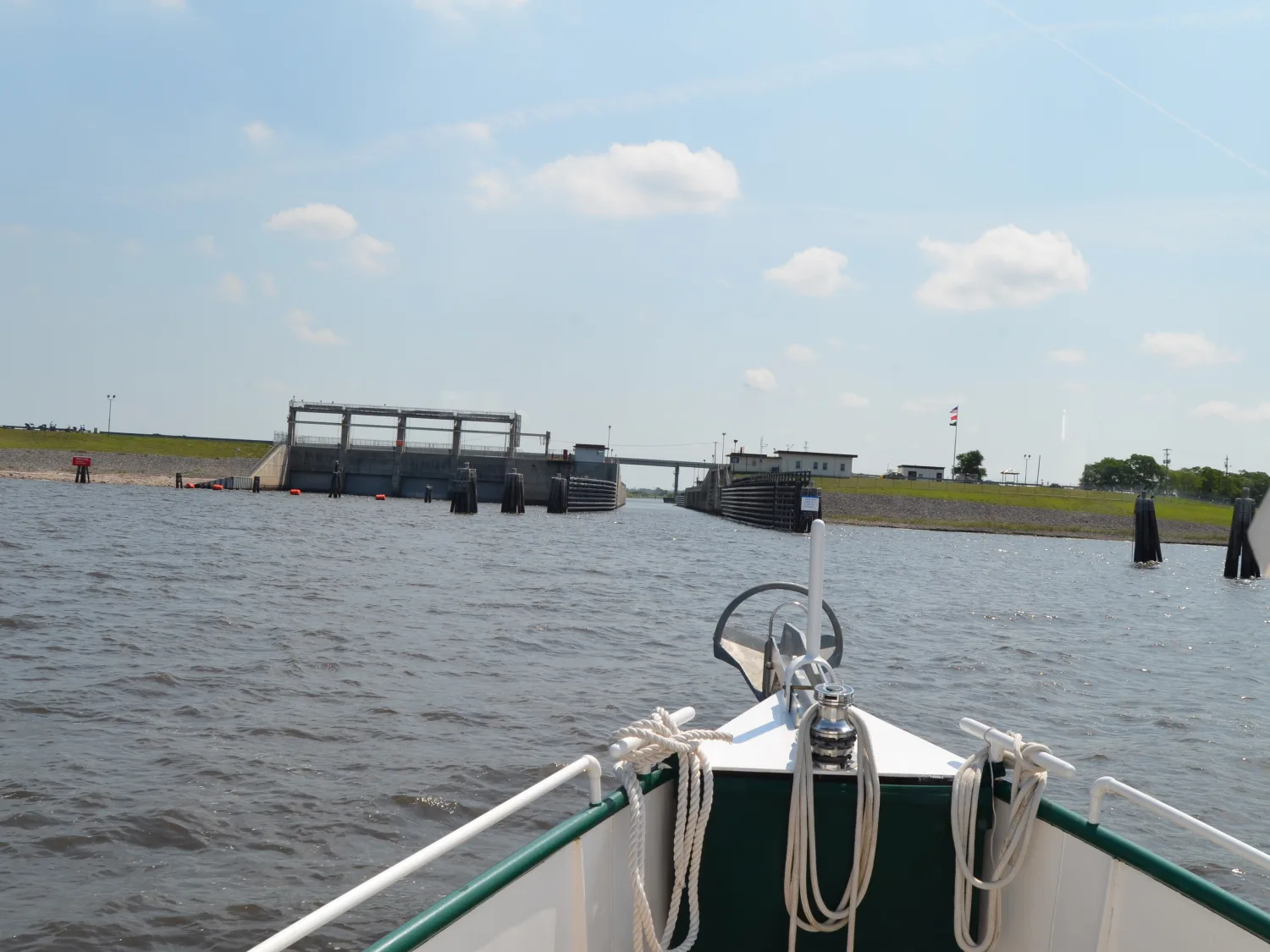 Sage's white bow, green rail, and coiled lines approaching a Florida lock entrance