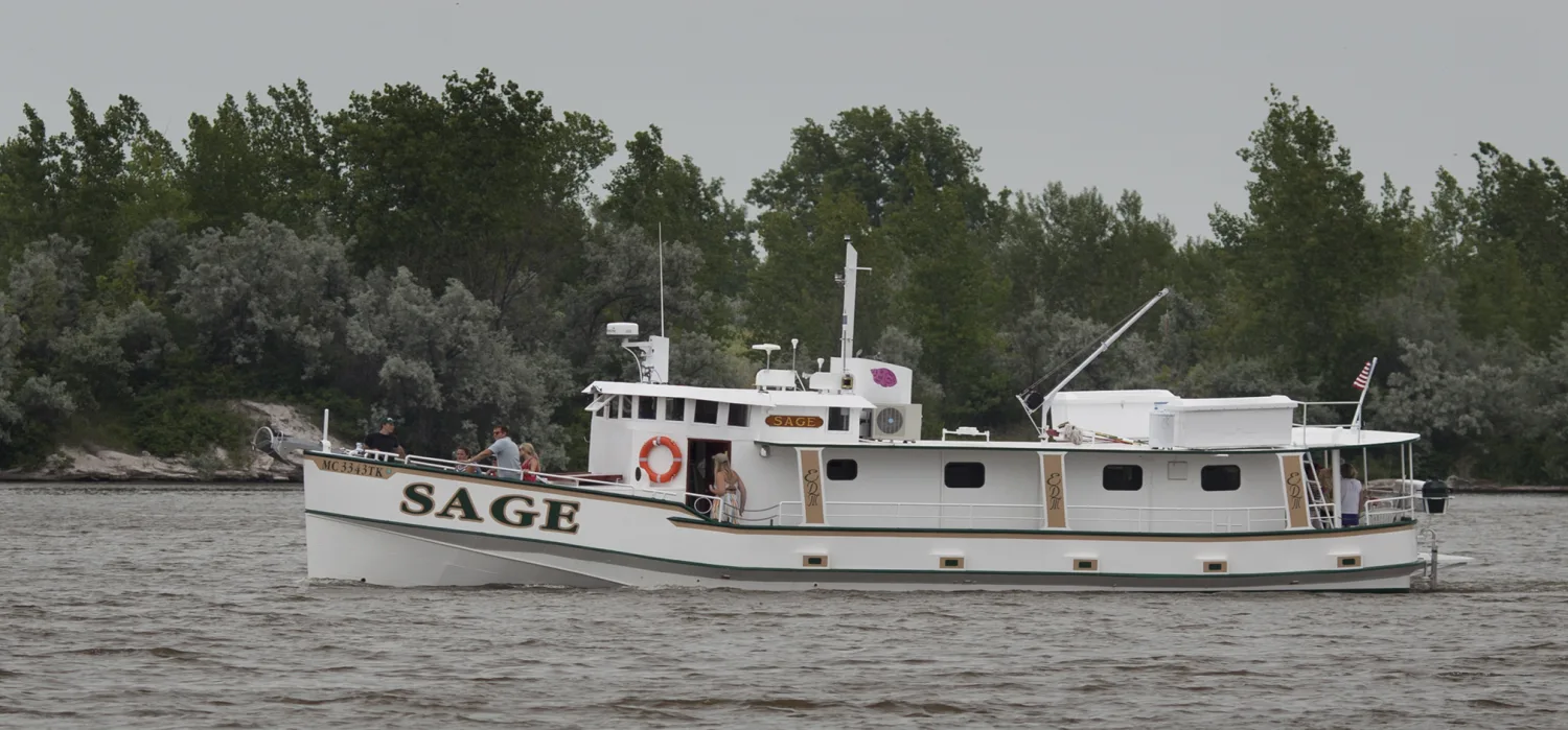 Sage cruising in full profile with several crew members aboard